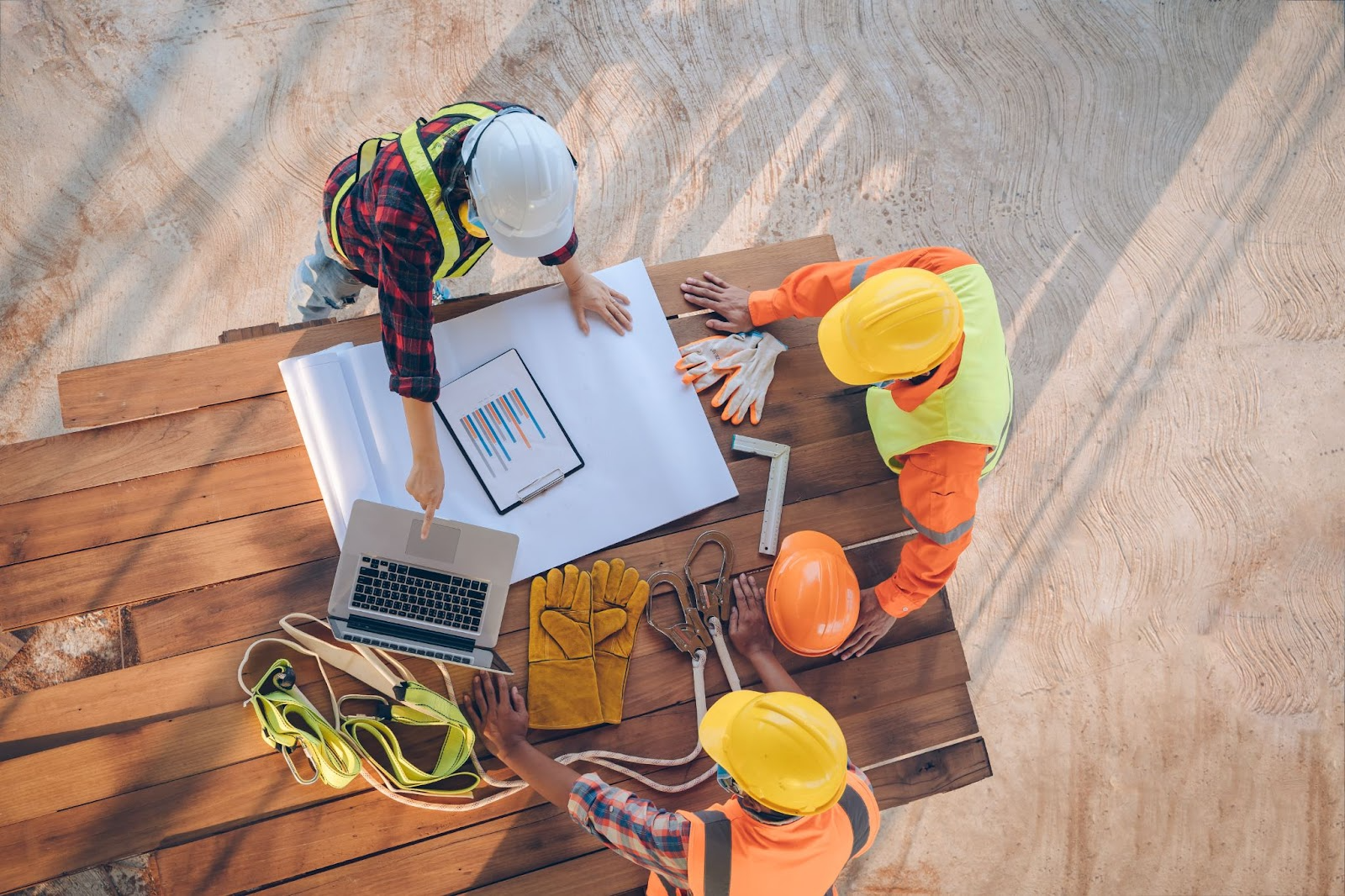 a group of construction workers and planners assess the validity of invoice factoring on site.